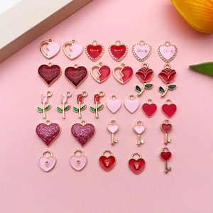 Flat lay of heart, rose, and key enamel pendants with glitter finish for DIY jewelry