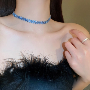 Dettaglio della collana girocollo in cristallo blu su un collo femminile molto elegante