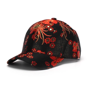 Detail of floral embroidery on black cotton baseball cap with golden thread and silk texture