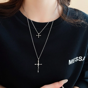 Detail of silver double-layered cross necklace with liquid lava style metal pendants