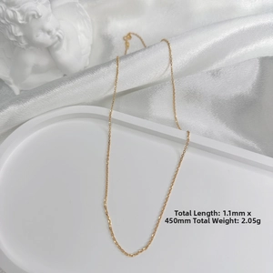 Detail of 1.1mm gold plated S925 silver cross chain necklace on elegant white tray