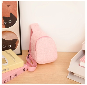 Close-up of pink teddy plush crossbody bag for kids on a minimalist wooden table