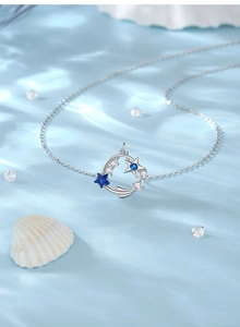 Detail of s925 silver necklace with blue star stones on blue silk with shells