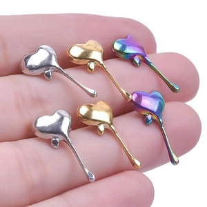Macro detail of melting heart drop earrings in silver, gold and rainbow stainless steel