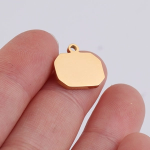 Close-up of a blank gold-tone stainless steel geometric pendant held by fingers