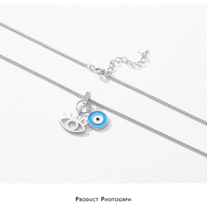 Detail of S925 silver necklace featuring sparkling pavé and blue enamel evil eye charms