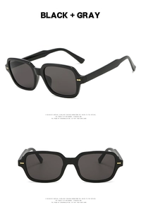 Detail of black square sunglasses with grey lenses and gold arrow rivet decorations