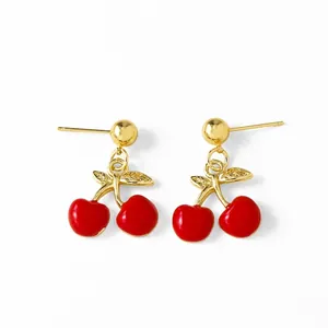 Sweet red enamel cherry stud earrings with golden alloy leaves on a white background