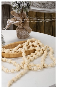 Detail of Christmas wooden bead garland on a tray with festive holiday decorations