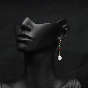 Detail of vintage baroque pearl earrings with black onyx beads on gold hoops