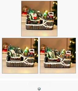 Dettaglio scena natalizia in resina con LED, casette innevate e figure di Babbo Natale