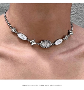 Detail of silver Y2K choker featuring rhinestone butterfly and white oval pendants