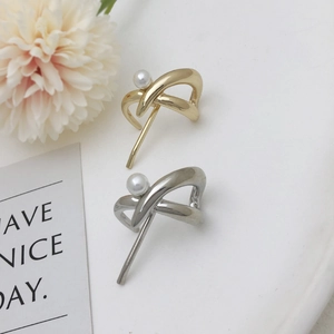 Minimalist gold and silver pearl hair clip accessories set on a white decorative tray