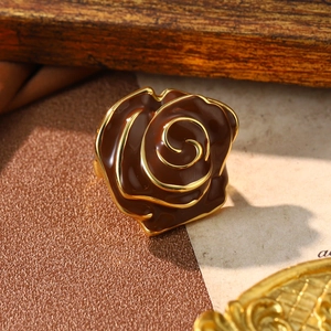 Detail of vintage brown rose ring with gold finish on rustic wood and paper background