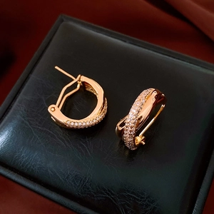 Macro shot of rose gold hoop earrings with cross-over pavé zircon stones and spring clasp
