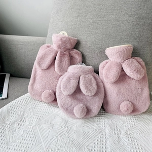 Pink rabbit faux fur hot water bottle covers with cute plush ears in a cozy home setting