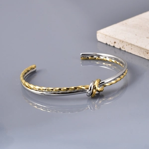 Minimalist twisted knot open cuff bracelet in two-tone gold and silver polished finish