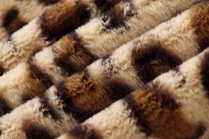 Close-up of fluffy leopard print faux fur fabric showing soft beige and brown textures