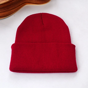 Gros plan détaillé sur la texture en maille côtelée rouge du bonnet classique à revers