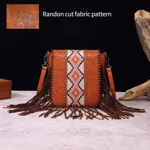 Detail of bohemian fringe bag featuring embossed leather and geometric floral ribbon