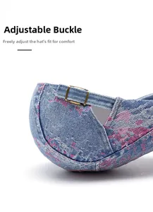 Dettaglio della fibbia metallica regolabile su basco in denim celeste con macchie rosa