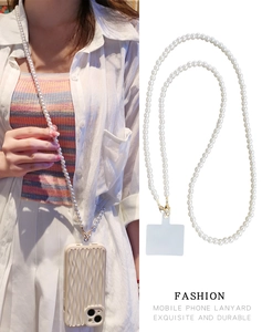 Detailed view of long white pearl phone lanyard with metal clasp and crossbody strap