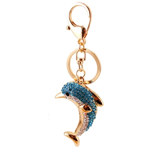 Golden dolphin keychain pendant with blue and white crystals on a plain white background