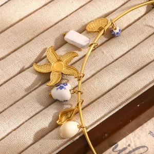 Detail of 18K gold plated bangle with starfish, baroque pearl and heart ceramic beads