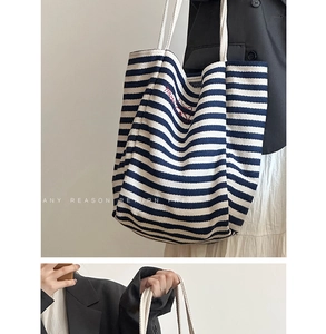 Detail of blue and white striped canvas tote with red embroidery and rope handles