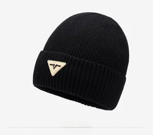 Close-up of black ribbed knit beanie featuring a triangle logo patch on the folded brim