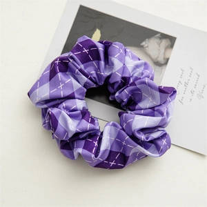Detail view of purple plaid scrunchie with satin luster and white diamond patterns