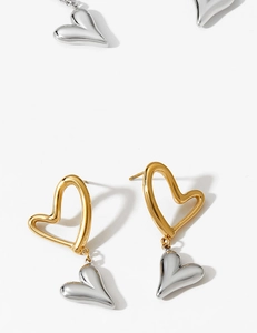 Macro shot of two-tone stainless steel heart earrings with gold and silver polished finish