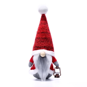 Handmade Christmas gnome with red knitted hat and lantern for Nordic holiday decoration