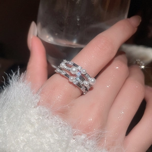Detail of elegant multi-layer silver ring with white pearls and sparkling cubic zirconia
