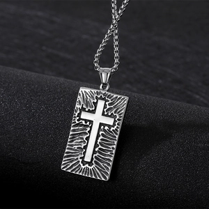 Gros plan d'un pendentif punk rétro en acier titane avec relief en croix et chaîne métal