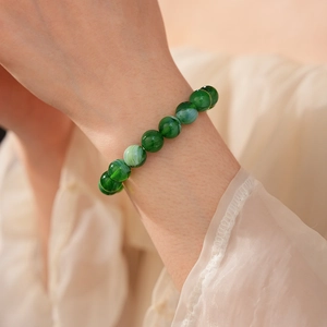 Detail of elegant green beaded bracelet with marble texture on female wrist