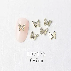 Detailed macro of 6x7mm gold mini butterfly nail art charm with micro-pave white rhinestones