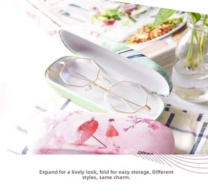 Detail of pink cherry blossom and green lining cases with gold octagonal glasses