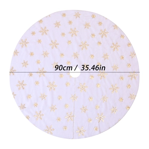Close-up of a white plush Christmas tree skirt with gold sequin snowflake patterns and size info