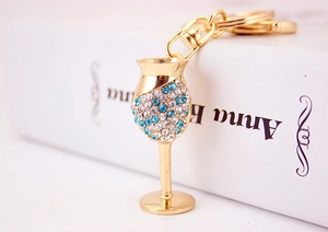 Detail of gold-plated wine glass keychain with sparkling blue and white rhinestones