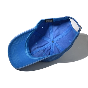 Detail of blue washed cotton baseball cap interior with stitching and 100% cotton label
