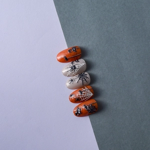 Detail of Halloween nail charms with 5D spider web and pumpkin orange press-on nails