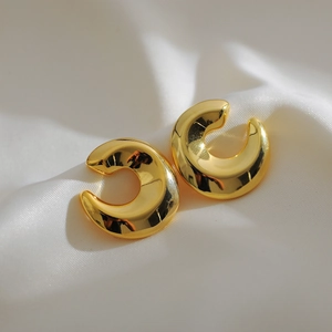 Chic 18K gold plated thick C-shape hoop earrings on elegant white silk fabric background