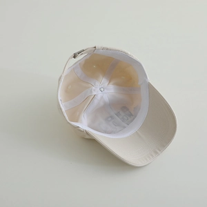 Detailed interior of beige cotton baseball cap with sweatband and metal buckle