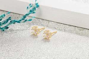 Close-up of elegant flower stud earrings with clear teardrop zircon petals in gold plating