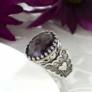 Gedetailleerd zijaanzicht van vintage barokke ring met paarse edelsteen en filigraan