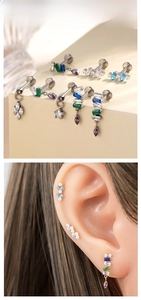 Detailed view of titanium ear studs with colorful zircon stones in various shapes and sizes