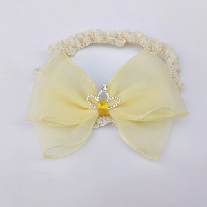 Detail of yellow lace baby headband with large mesh bow and silver crown rhinestone