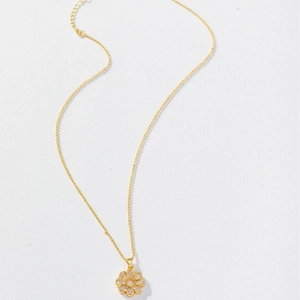 Elegant gold sunflower pendant necklace with cubic zirconia on white background