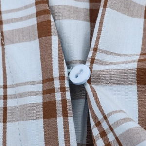 Detailed close-up of blue and brown plaid fabric texture and a matching blue round button